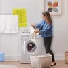 A woman is doing laundry in a laundry room. Anteprima dell’immagine prodotto