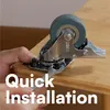 A close-up of a hand installing a caster wheel on a wooden surface. Produktbild-Vorschau