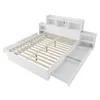 A white bed frame with storage drawers and attached nightstands, shown from a slightly elevated diagonal angle against a white background. Produktbild-Vorschau