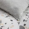 A close-up view of a bedding set with a terrazzo-like pattern. Produktbild-Vorschau