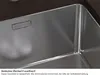 A close-up view of a stainless steel sink with a branded logo and text describing a feature. Produktbild-Vorschau