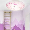 A child's room with a wooden gymnastic ladder and a pink ceiling light with unicorn and star motifs. Produktbild-Vorschau