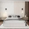 A bedroom scene featuring a bed with a headboard, nightstands, and wall decor. Produktbild-Vorschau