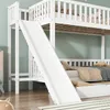 A white bunk bed with a slide and a drawer underneath, set against a light green wall. Anteprima dell’immagine prodotto