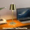 A gold table lamp with dimensions indicated by measurement lines and text, placed on a desk with a blurred laptop in the background. Anteprima dell’immagine prodotto