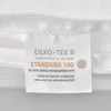 A close-up of a white textile label with OEKO-TEX certification. Podgląd zdjęcia produktu
