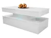 A white, modern coffee table with a glossy finish and blue LED lighting is shown against a white background. Two gold decorative spheres sit on top of the table. Produktbild-Vorschau