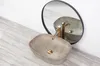 A beige countertop sink with a gold faucet is shown in front of a mirror. Anteprima dell’immagine prodotto