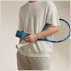 A person holding a blue phone case and a tennis racket. Náhľad obrázku produktu