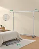 A mobile garment rack is shown next to a bed, with a collapsed version of the rack shown on the floor. There are indicators showing adjustability. Náhled obrázku produktu