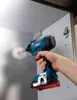 A hand is using a Bosch impact driver to screw a fastener into the interior of a cabinet. Anteprima dell’immagine prodotto