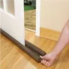 A hand is shown adjusting a draft stopper under a door. Anteprima dell’immagine prodotto