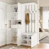 A white entryway furniture set with storage, a bench, and coat hooks, set against a doorway and a living room in the background. Anteprima dell’immagine prodotto