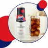 A bottle of Pepsi Max Cherry syrup next to a glass of cola with ice. Produktbild-Vorschau