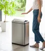 A person is using a sensor-activated trash can in a modern home setting. Podgląd zdjęcia produktu