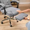 A person's hands are shown interacting with a gray office chair, specifically extending a footrest. Produktbild-Vorschau