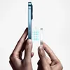 Hands holding a smartphone and a magnetic charger, with magnetic field lines illustrated between them. Produktbild-Vorschau
