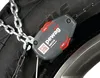 A close-up of a snow chain attached to a tire, with a focus on the Pewag Servo tensioning device. Produktbild-Vorschau