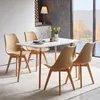 A dining set with four chairs and a table in a modern dining room with a large window overlooking a natural landscape. Voir les images du produit