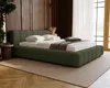 A bedroom scene with a green upholstered bed as the focal point. Náhled obrázku produktu