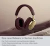A pair of burgundy and gold over-ear headphones are displayed against a soft, abstract background. Produktbild-Vorschau