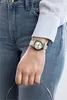 A person wearing a watch and jeans. Produktbild-Vorschau