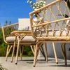 A close-up shot of a rattan outdoor furniture set on a patio, with a cup of coffee on the table. Náhled obrázku produktu