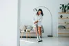 A woman is vacuuming a living room floor while wearing headphones. Voir les images du produit