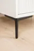 A close-up view of the black metal legs of a white cabinet. Produktbild-Vorschau