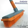 Close-up of a broom with orange bristles and a gray and orange handle, with water droplets in the foreground. Produktbild-Vorschau