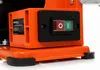 A close-up of an orange power switch on a machine. Voir les images du produit