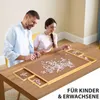 A man and a woman are sitting at a table and doing a puzzle. Produktbild-Vorschau