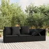 A black outdoor lounge bed with cushions is placed on a wooden deck, surrounded by lush green trees and foliage. Náhľad obrázku produktu