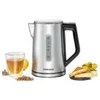 A silver electric kettle with a black handle is shown on a white background, next to a glass of tea and some tea ingredients. Náhled obrázku produktu