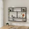 A modern black metal wall shelf with multiple compartments, decorated with plants, books, framed pictures, and decorative blocks, above a wooden desk. Anteprima dell’immagine prodotto