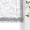 A close-up view of a gray roman blind with a white damask pattern, partially covering a window. Produktbild-Vorschau