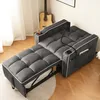A dark gray convertible sofa bed is shown in a room with a guitar in the background and a rug on the floor. Produktbild-Vorschau