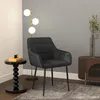A black velvet dining chair is placed next to a small black side table and a floor lamp with three globes. Podgląd zdjęcia produktu