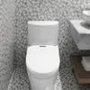 A white bidet toilet seat is shown in a bathroom with mosaic tile walls. Podgląd zdjęcia produktu