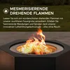 A close-up of a black, hexagonal fire pit with flames burning inside, set outdoors on a patio with grass in the background. Náhled obrázku produktu