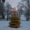 A decorated Christmas tree in a snowy outdoor setting at dusk. Podgląd zdjęcia produktu