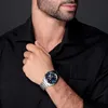 A man wearing a black shirt and a silver watch. Produktbild-Vorschau