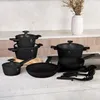 A collection of black cookware and utensils arranged on a countertop. Náhled obrázku produktu