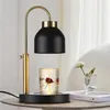 A candle warmer lamp is placed on a table next to a small vase with a flower. Náhled obrázku produktu