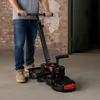 A person is operating a concrete grinder in a warehouse or industrial setting. Produktbild-Vorschau