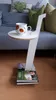 A side table with a mug on top, placed next to a sofa, with books forming its base. Produktbild-Vorschau