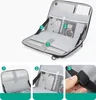 An open tech organizer bag with various compartments and accessories inside. Náhled obrázku produktu