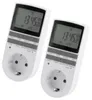 Two white digital timers with electrical outlets are shown against a white background. Produktbild-Vorschau