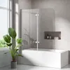 A modern bathroom with a bathtub, shower screen, and a potted plant. Podgląd zdjęcia produktu