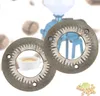 Two grinding discs for a coffee grinder are shown in the foreground, with a blurred coffee grinder and coffee beans in the background. Voir les images du produit